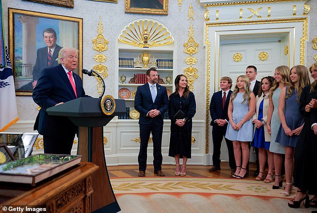 The Mullins and their six children stand as Trump speaks