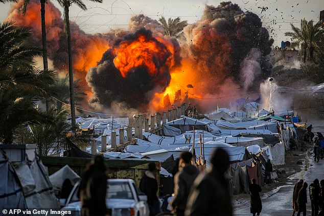 Israel is engaging in a wide range of military strikes across the Middle East, including in Gaza and Lebanon, where Iran's proxies are active against Netanyahu's forces (pictured: a fireball erupts following an Israeli strike near a tent encampment sheltering people displaced by war in Deir el-Balah in the central Gaza Strip on March 25)