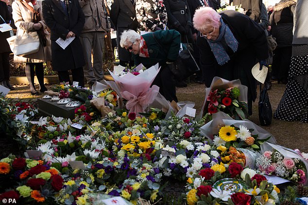 Members of the public place flowers at a memorial near St Andrew's Church Kegworth in 2019