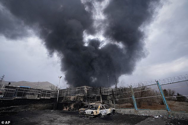 A plume of smoke rises over an oil storage facility hit by US-Israeli strikes on March 8