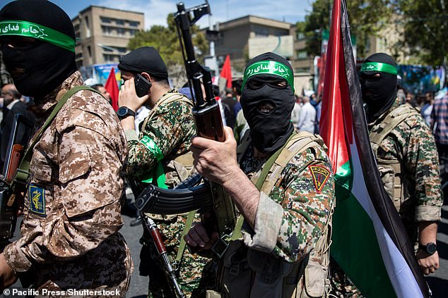 member of the Islamic Revolution Guard Corps shows his AK47 weapon during an annual rally to mark Quds Day, or Jerusalem Day, in support of Palestinians