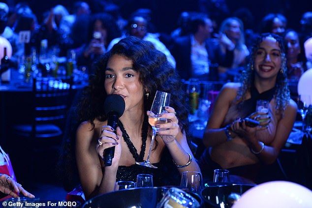 As she spoke to the audience, Olivia cheered to her success and sipped champagne