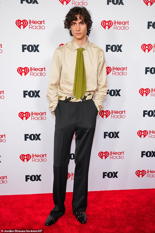 Sombr smoldered on the red carpet in a silky dress shirt, green tie and baggy black trousers