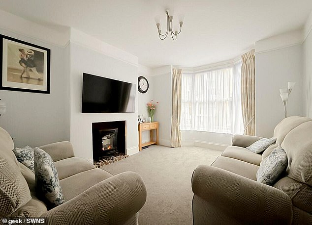 Bay windows lets streams of light into the living room which has a fire too