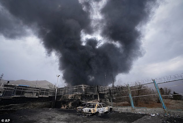 A thick plume of smoke rises from an oil storage facility hit by a U.S.-Israeli strike in Tehran, Iran, March 8, 2026