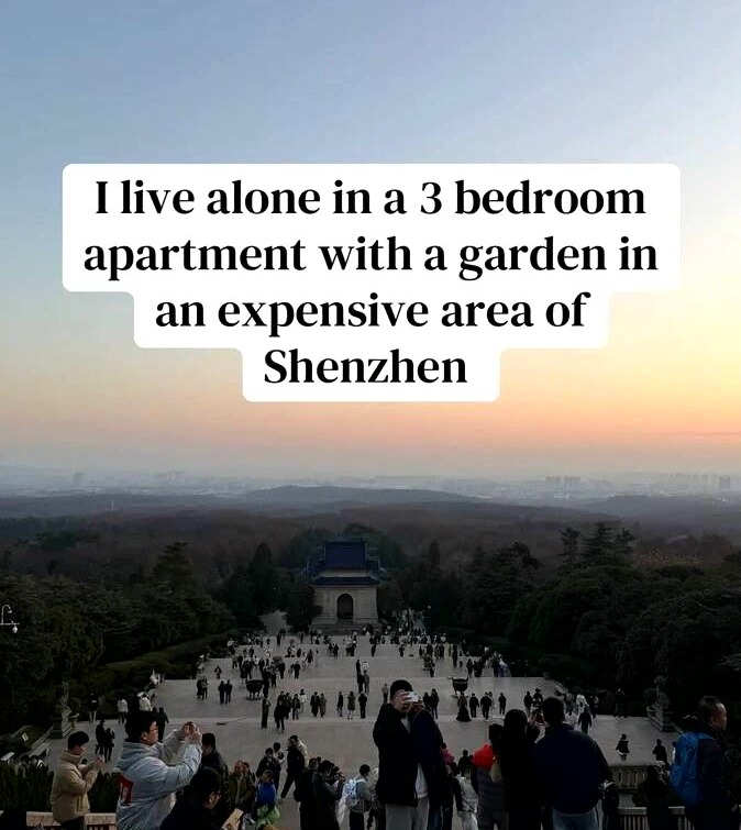 Overhead shot of a busy outdoor staircase leading up to a large building, with a sunset sky and a city skyline in the distance.
