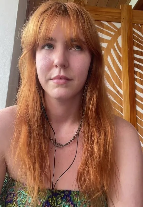 A red-haired woman wearing earphones and a strapless top looks upward with the text "1 min later" above her.