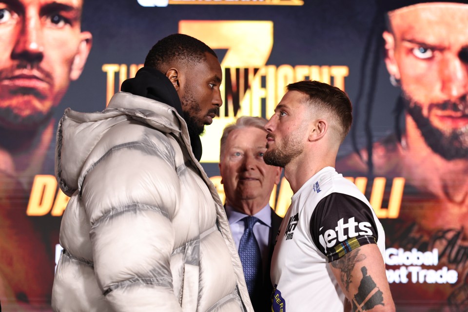 Two boxers stare intensely at each other during a press conference face-off.