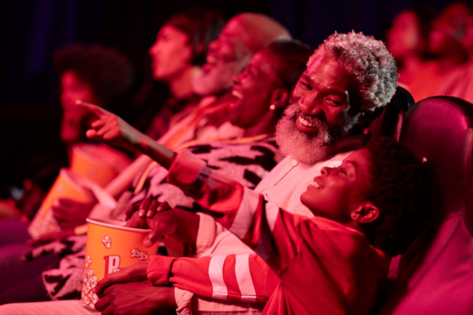 Happy father and daughter watching a show in a theater.