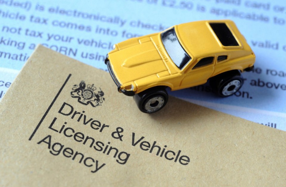 Yellow toy car on a document from the Driver & Vehicle Licensing Agency.