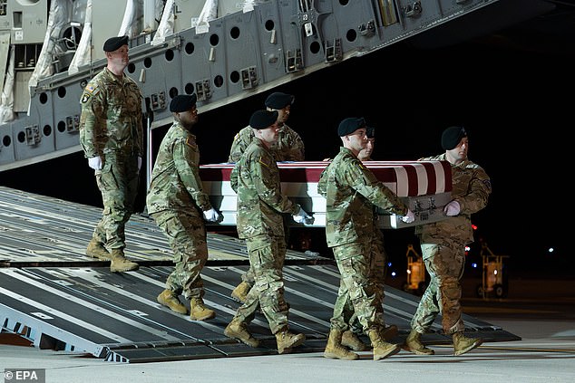 Service members carry the casket of a deceased soldier as it arrives at Dover Air Force Base on March 9. Thirteen American service members have died amid Operation Epic Fury, with more than 300 wounded
