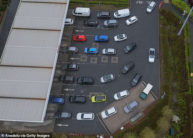 In a blow for families gearing up for the Easter getaway next week, average petrol prices have surged past 150p a litre for the first time since May 2024. Pictured: Drivers queue at a petrol station in Derby on Friday