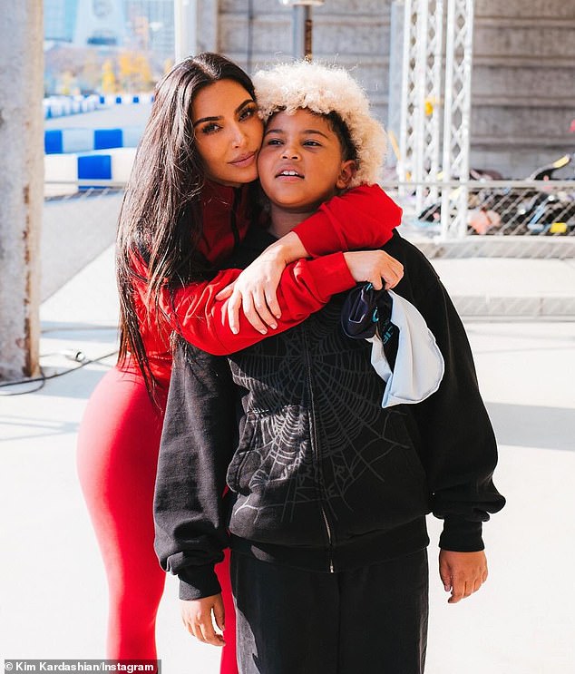 She better showed off her outfit for the day as she hugged Saint while sporting the racing jacket and fitted red leggings