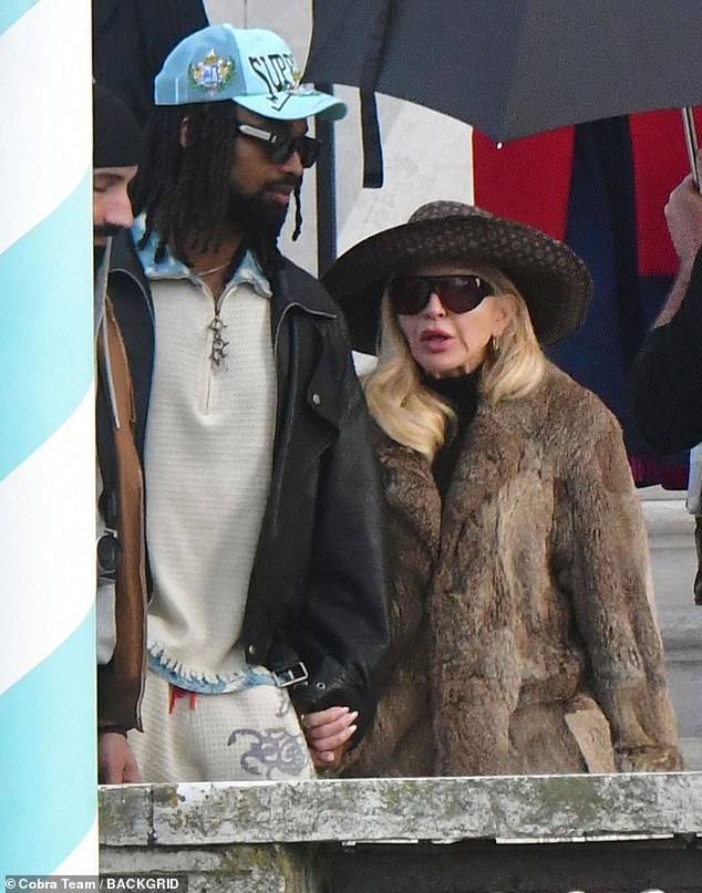 Akeem, 29, who is 38 years younger than his girlfriend, cut a casual figure in a white quarter-zip jumper and matching tracksuit bottoms