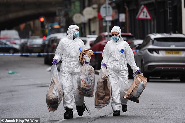 Forensic investigators carrying evidence bags at the scene in Friar Gate