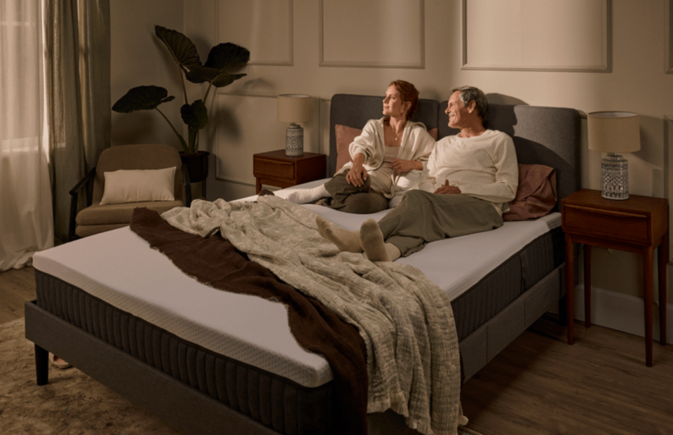 A couple relaxing on a mattress in a bedroom.