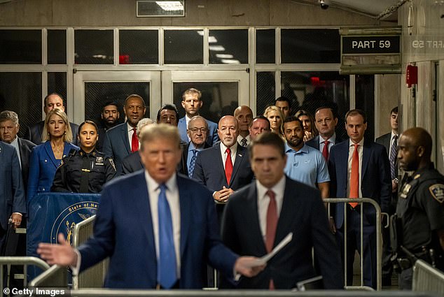 Dershowitz has written a book about how Trump could constitutionally serve a third term. He is pictured in glasses and a blue shirt and tie among a sea of legal professionals standing behind Trump as he made a speech during his fraud trial at Manhattan Criminal Court in May 2024