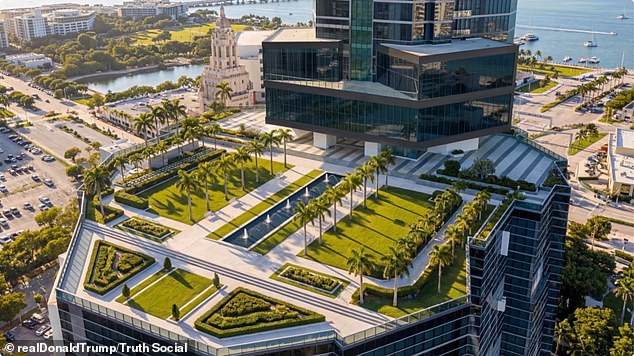 A roof deck is lines with palm trees and a possible replica of the White House's Rose Garden