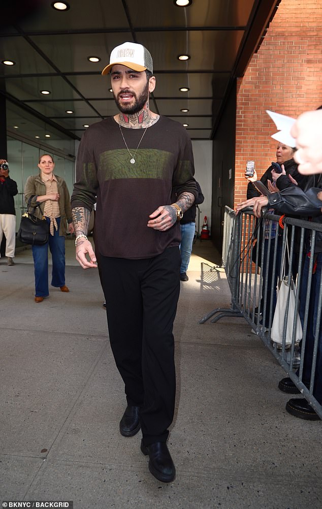 The singer, 33, wore a brown and green top, black trousers and a 'Drew' cap, from the show