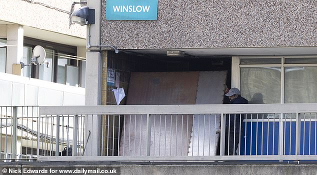 Workers reinstalling metal panelling to seal off a flat, after squatters managed to break in