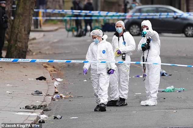 Forensic investigators are pictured at the scene in Derby on Sunday morning