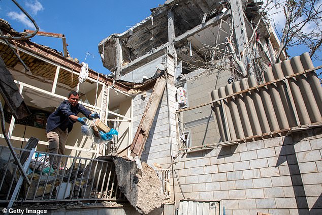 A man clear rubble leftover from drone attack on a residential building in Tehran, Iran on Tuesday