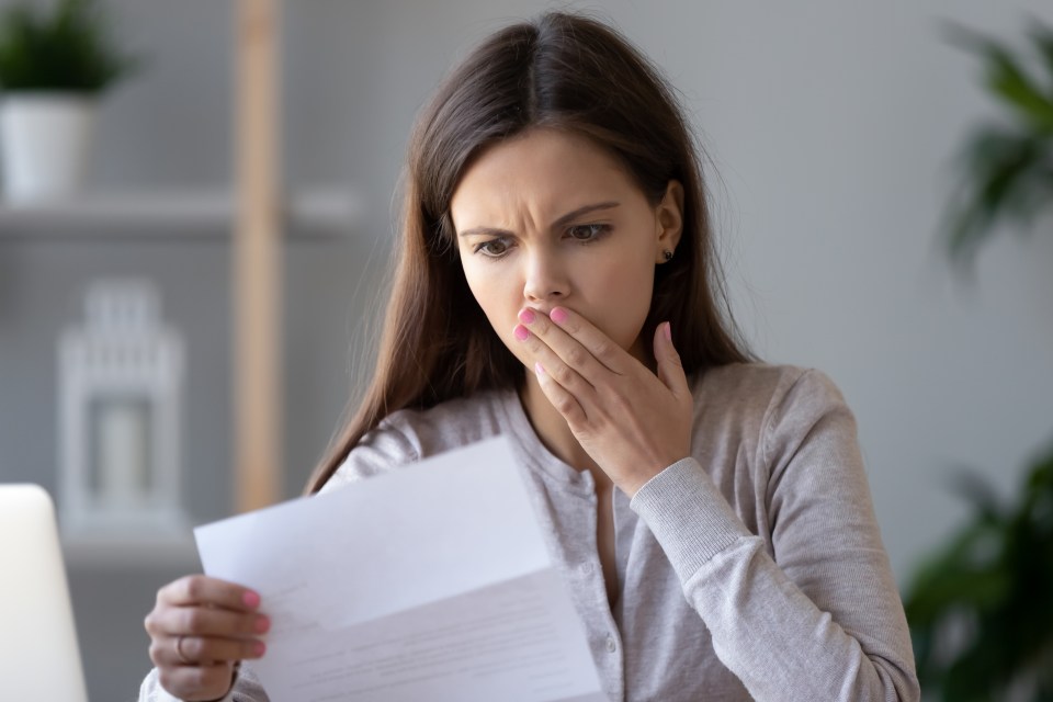 A shocked young woman reacts to bad news in a letter.