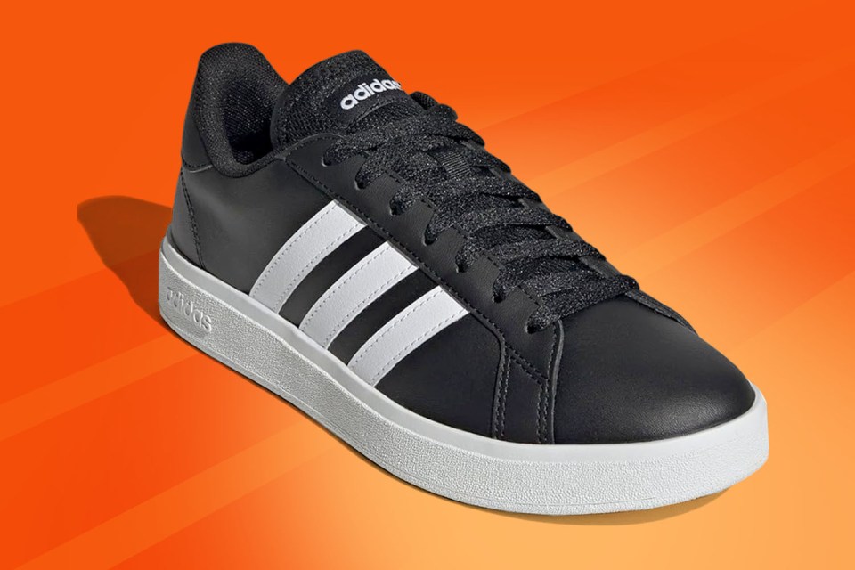 A black Adidas sneaker with white stripes and a white sole.