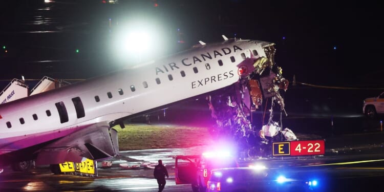 An Air Canada Express plane sits on the tarmac after a crash at LaGuardia Airport on March 23, 2026.