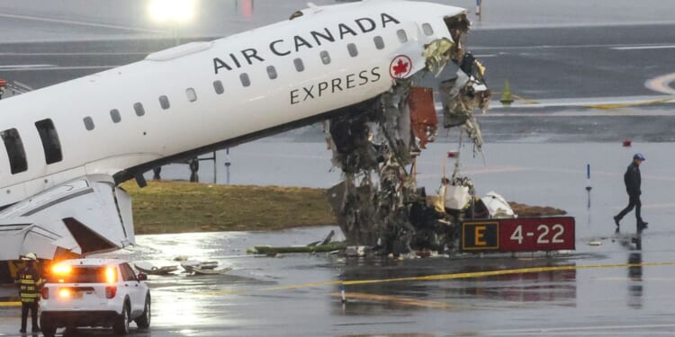 An Air Canada Express CRJ-900 sits on the runway Monday after colliding with a Port Authority fire truck Sunday night at LaGuardia Airport in New York.