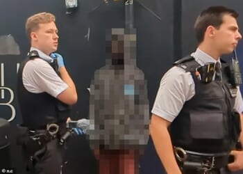 A photo taken in the aftermath captured the man staring ahead at members of the public as the police detained him after he terrified a blind woman by bursting into her home