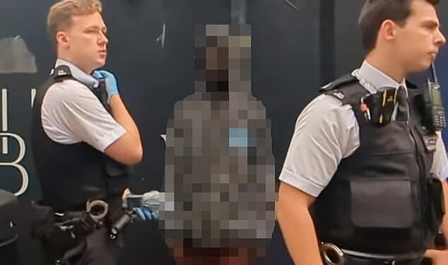 A photo taken in the aftermath captured the man staring ahead at members of the public as the police detained him after he terrified a blind woman by bursting into her home