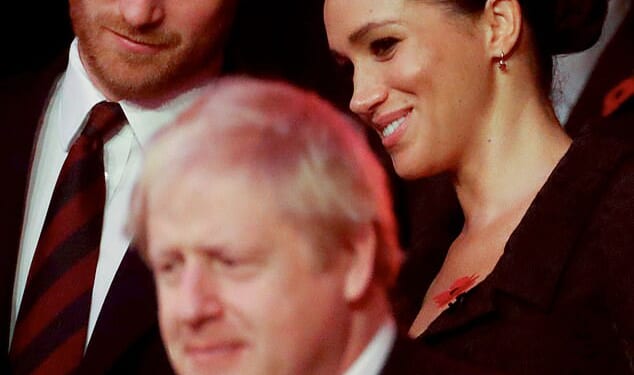 Former PM and Daily Mail columnist Boris Johnson sits in front of Prince Harry, Duke of Sussex, and Meghan, Duchess of Sussex at a remembrance service in 2019