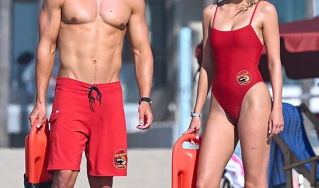 Baywatch newcomer Jessica Belkin slipped into the iconic red swimsuit for the first time as she joined shirtless co-star Noah Beck to film the show reboot on the beach in LA this week