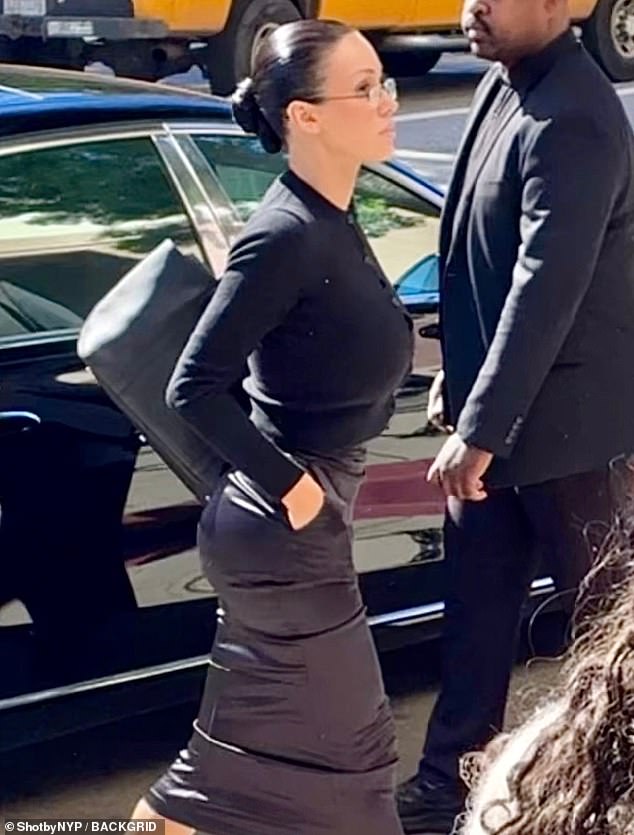 The Australia-born model and architect, 31, appeared unusually conservative in a black cardigan paired with a long skirt