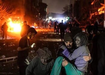 A man carries an injured woman at the site of US-Israeli airstrikes in Tehran, Iran on Monday
