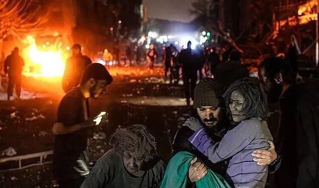 A man carries an injured woman at the site of US-Israeli airstrikes in Tehran, Iran on Monday