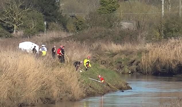 Emergency workers are pictured at the scene of the hunt for the missing teenagers in Cambridgeshire