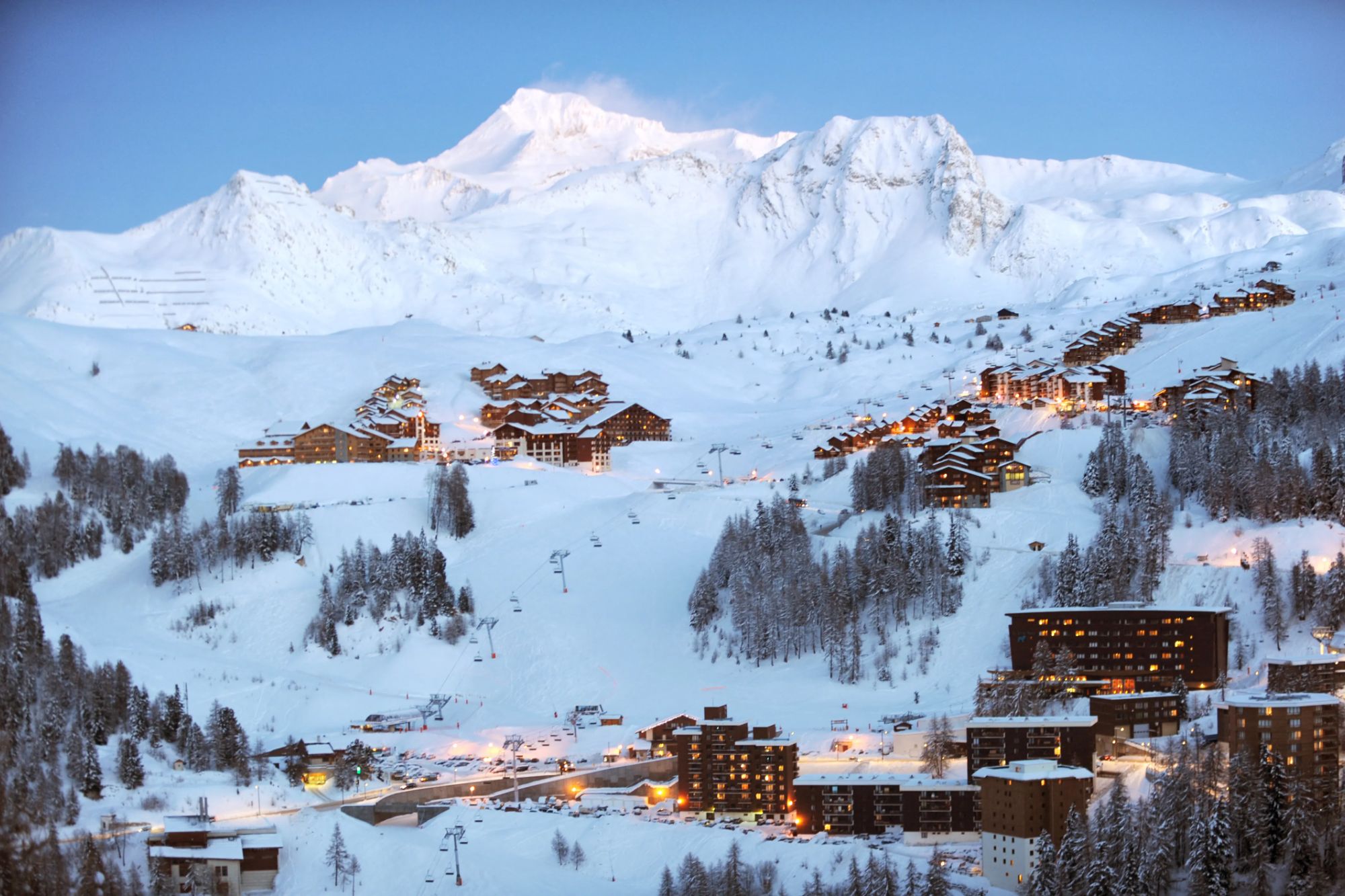 An image collage containing 1 images, Image 1 shows La Plagne ski resort in the French Alps with snowy mountains, residential buildings, and ski lifts