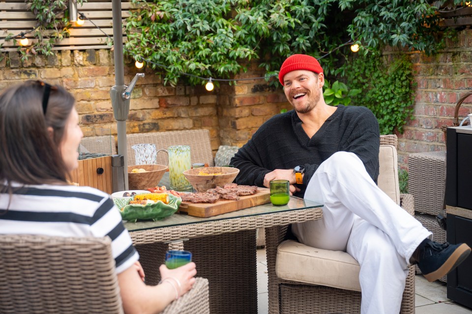 Two people enjoying a barbecue on a patio.