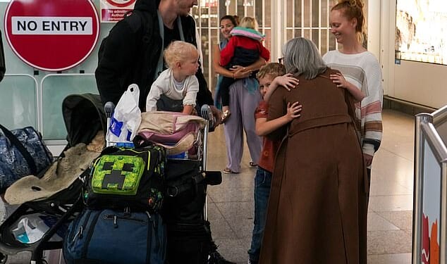 Brits pictured arriving at Stansted Airport early this morning, after a 'traumatic' journey back from the Middle East