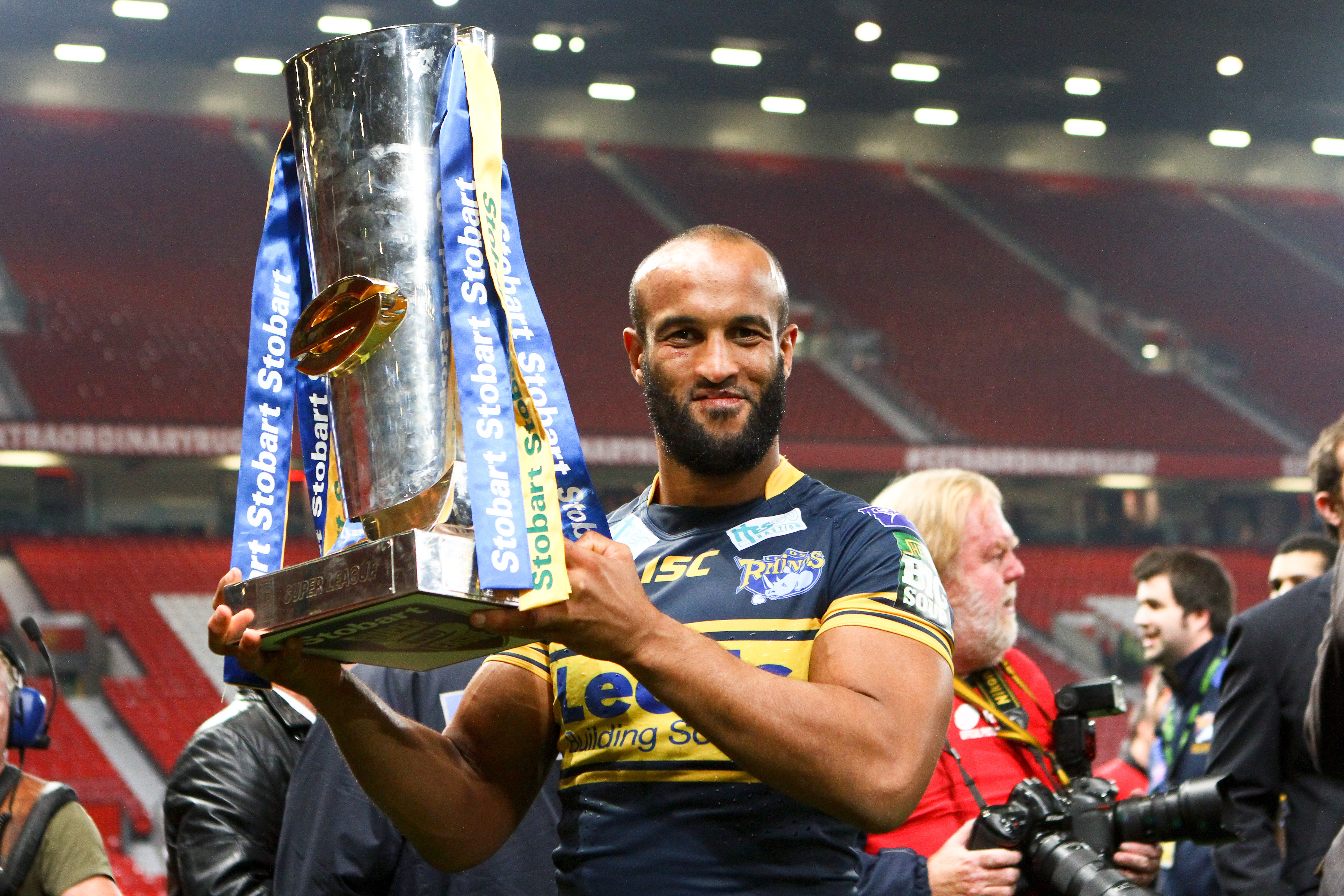 A Leeds Rhinos player holding the Super League trophy.