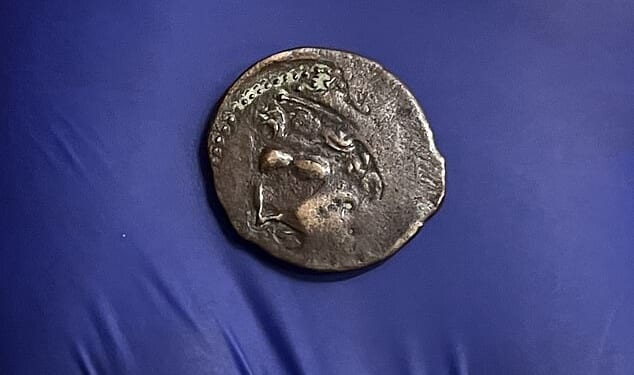 On one side the coin features the face of the god Melqart, resembling the Greek hero Herakles and wearing his famed lionskin headdress
