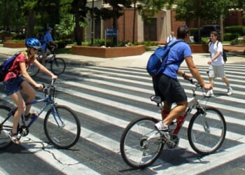 University of Florida students make their way through a crosswalk near the campus landmark Century Tower in Gainesville, Florida.