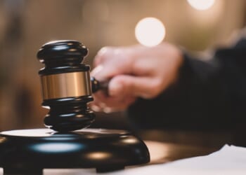 A judge's hand holding a gavel.