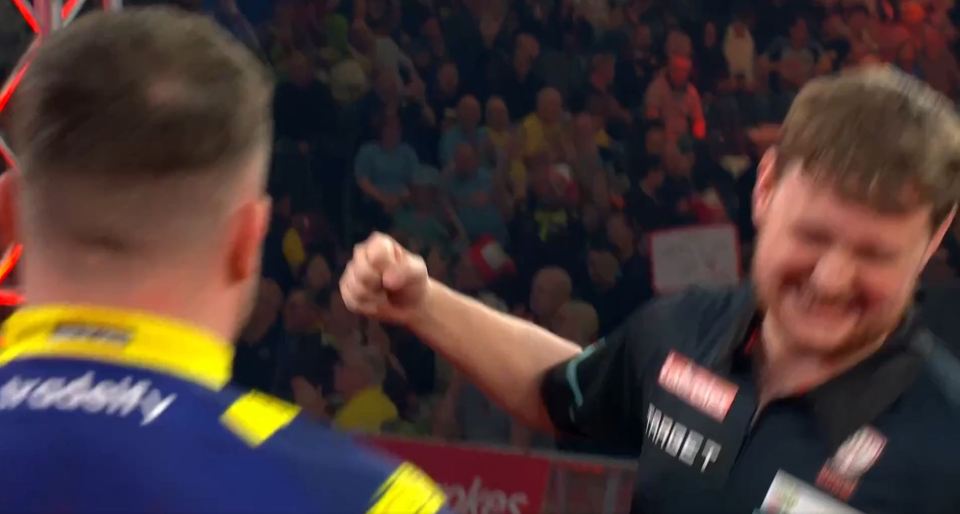 Darts player Kevin Doets playfully "punches" Luke Littler after a UK Open defeat.