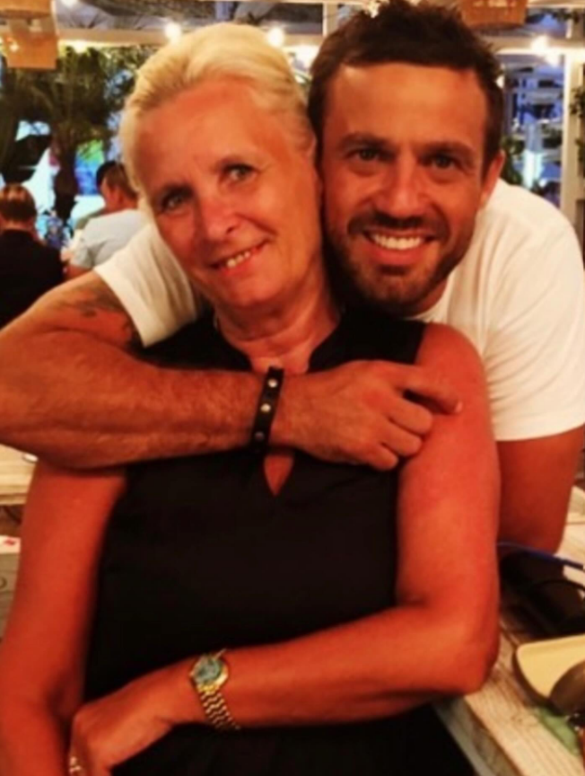 A man in a white shirt with an arm around a woman in a black shirt.