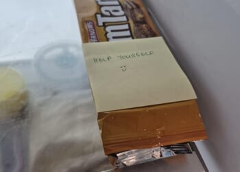 An office worker recently sparked debate online after discovering a note placed on their personal snacks in the workplace fridge - inviting everyone to help themselves