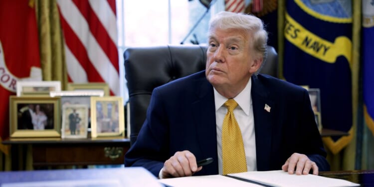 President Donald Trump prepares to sign paperwork during a White House signing ceremony in the Oval Office on March 16, 2026, in Washington, D.C.