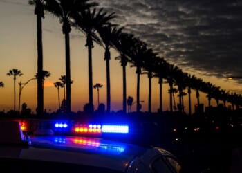 A police car goes by with lights activated on Gene Autry Way in Anaheim, California.